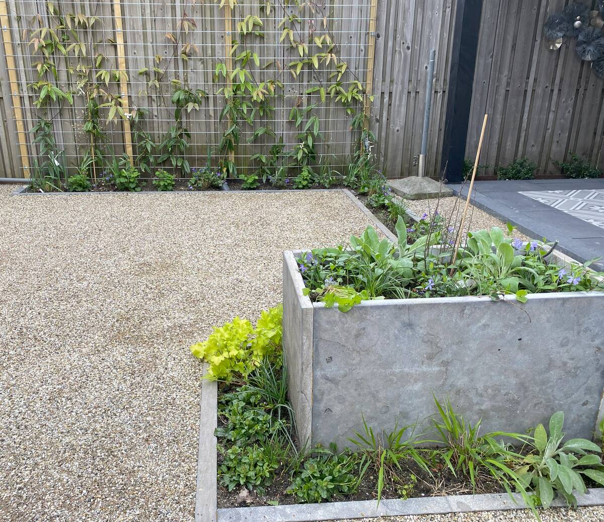 Verhoogde plantenbak gemaakt van hergebruikte grote tegels uit de tuin.